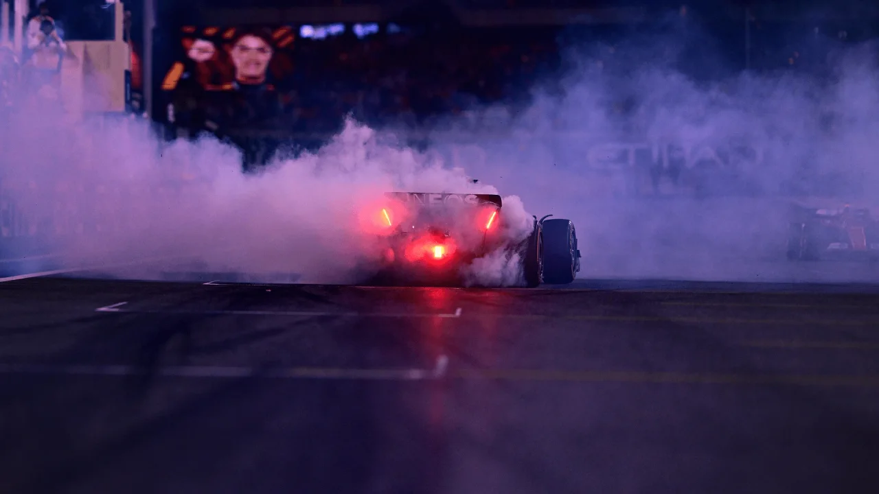 Formula 1 car with illuminated rear lights at the Abu Dhabi circuit