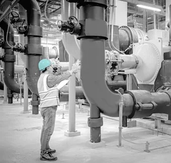 Maintenance technician inspecting industrial pipework