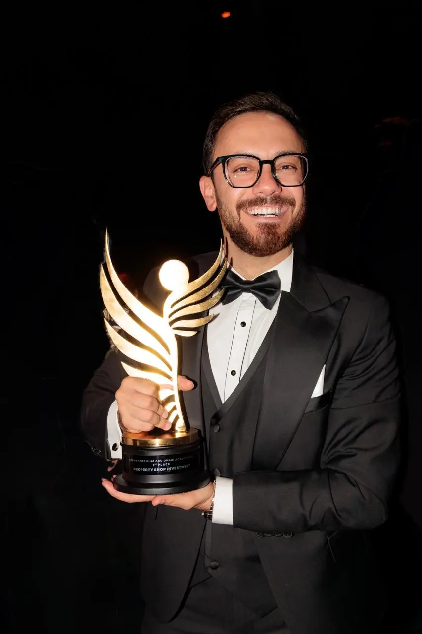 Beshoy Abdou smiling while holding an award at an event